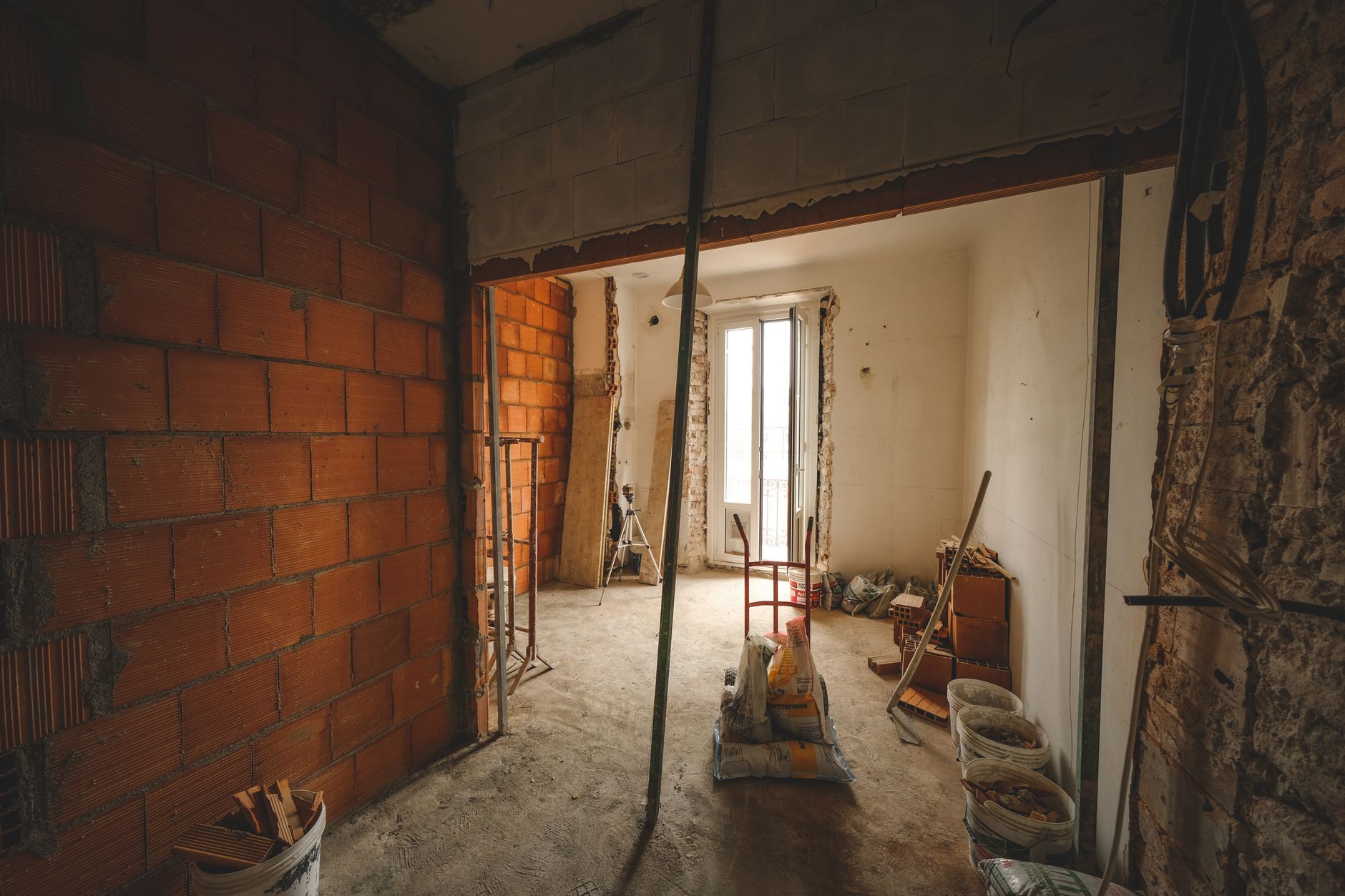 A partially renovated room with exposed brick walls and construction materials on site. — Securing Outdoor Spaces with Style: