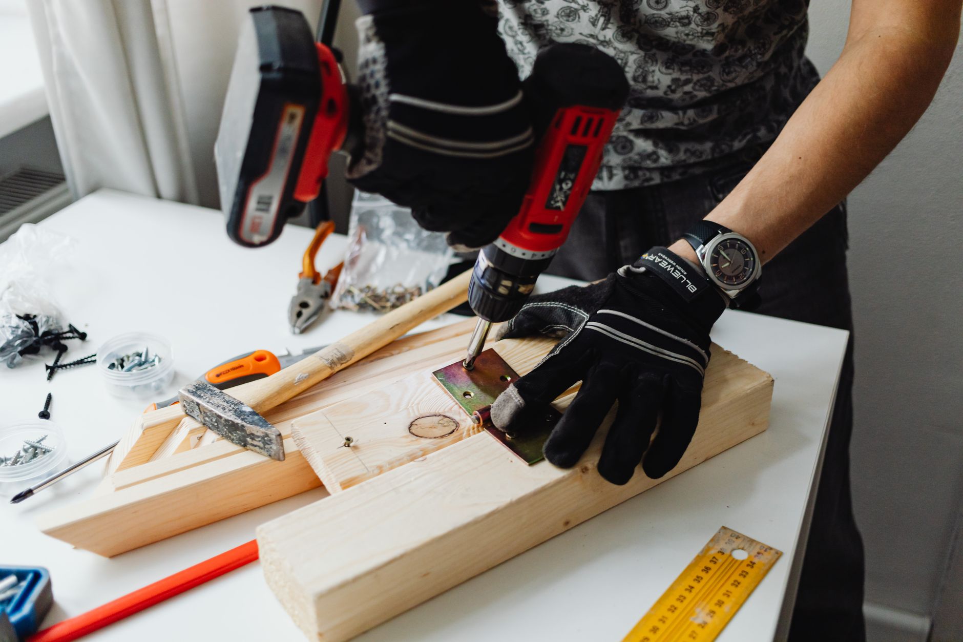 A craftsman uses a power drill on wood, showcasing carpentry tools and skills. — Siding Solutions That Elevate Curb Appeal in