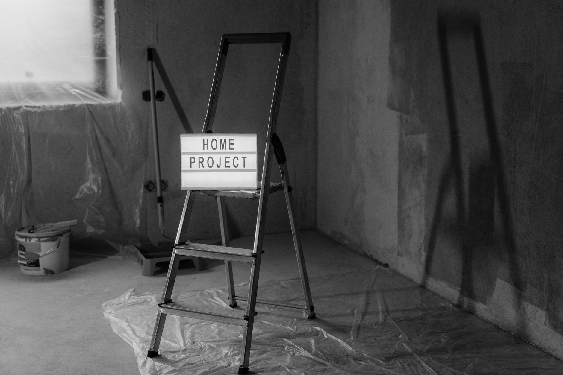Black and white image of a step ladder with a 'home project' sign in a renovation setting. — Signs of Hidden Water Leaks Insi